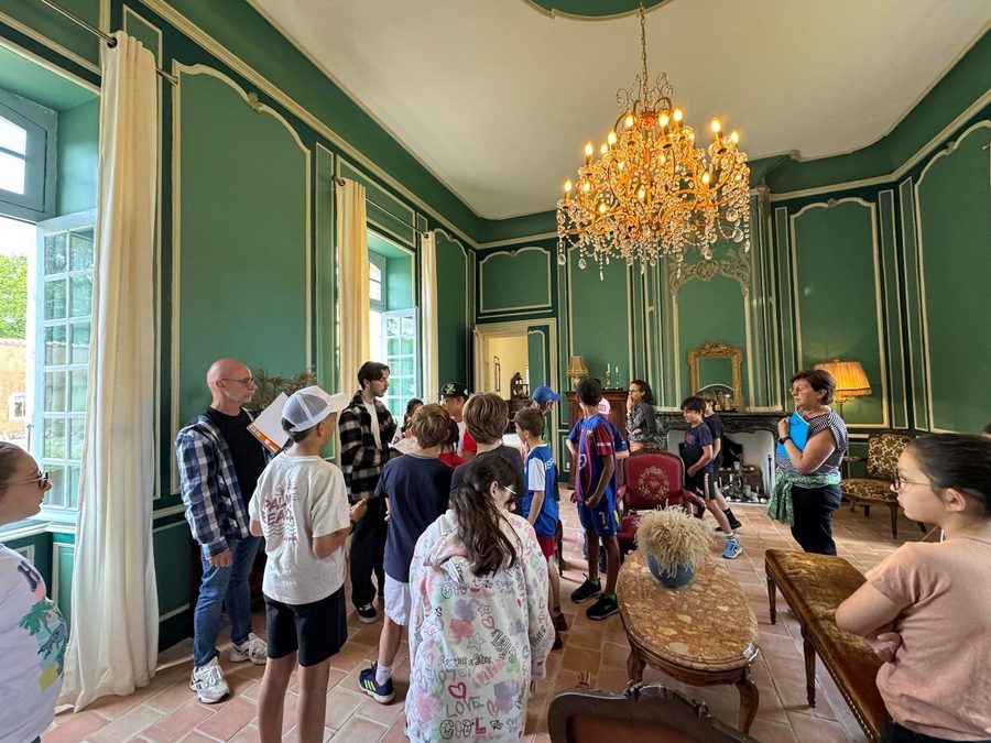 Élèves découvrant le salon vert du château sous le lustre de cristal